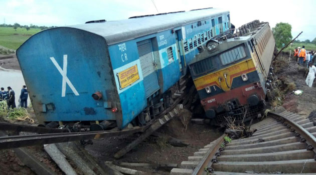 Two passenger train carriages lie next to each other following a derailment after they were hit by flash floods on a bridge outside the town of Harda in Madhya Pradesh state, central India on August 5, 2015/AFP