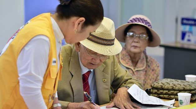 An elderly South Korean man who left behind relatives in the North, fills out an application for an expected inter-Korean family reunion, at the Red Cross office in Seoul, on September 7, 2015/AFP