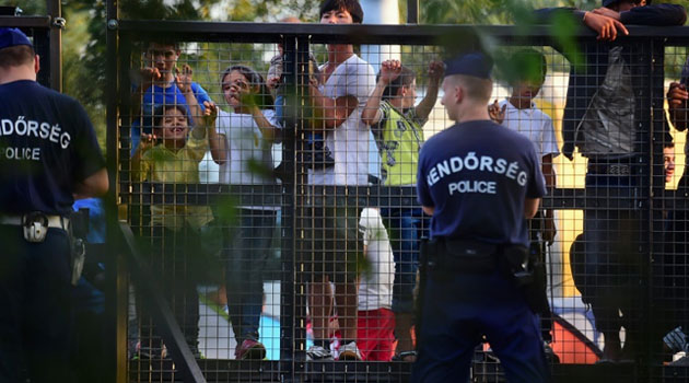 Hungarian police stand guard in front of a metal gate at the closed M5 highway to block migrants at the Hungarian-Serbian border near Roszke station on September 15, 2015  © AFP Attila Kisbenedek