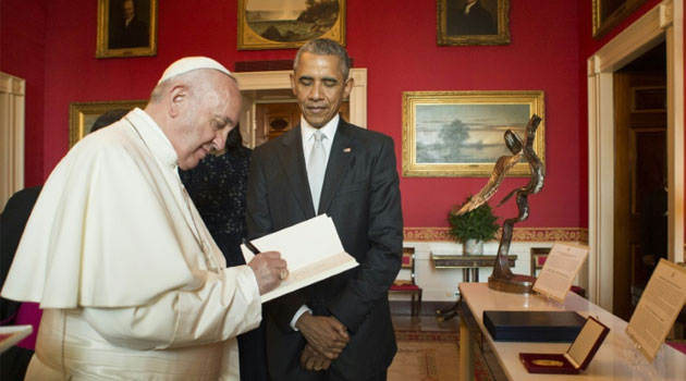 This photo released by L'Osservatore Romano shows Pope Francis with US President Barack Obama as he signs the ecological encyclical at the White House, September 23, 2015 in Washington, DC/afp