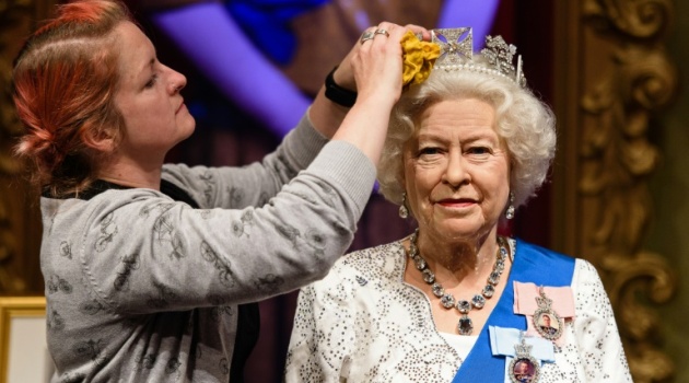 Stylist Jane Anderson poses with the re-styled wax figure of Queen Elizabeth II, during a photocall at Madame Tussauds in London on September 7, 2015/AFP 