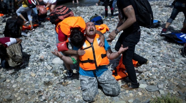 A refugee from Syria prays after arriving on the shores of the Greek island of Lesbos on September 7, 2015/AFP  