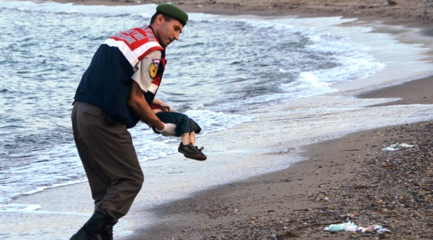 A Turkish police officer carries Aylan Kurdi's body off the beach in Bodrum, on September 2, 2015, after a boat carrying refugees sank while trying to reach the Greek island of Kos/AFP 