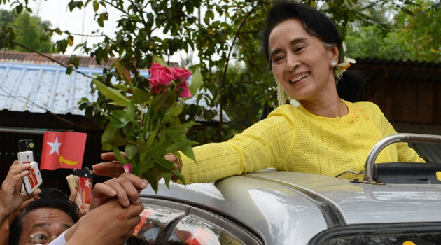 Myanmar opposition leader Aung San Suu Kyi receives roses from a supporter during a campaign rally for the National League for Democracy/AFP