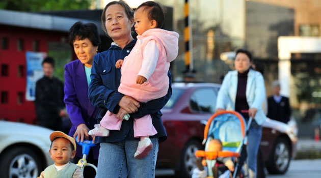 Chinese parents strolling with their children/FILE