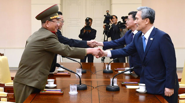 Representatives from North Korea (L) and the South shake hands as they meet at the truce village of Panmunjom, in August 2015  © S.Korean Unification Ministry/AFP/File