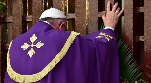 Pope Francis symbolically opens a gate to peace at Bangui Cathedral in the Central African Republic on November 29, 2015, appealing during a landmark mass to warring factions and urging them to "lay down these instruments of death"/AFP