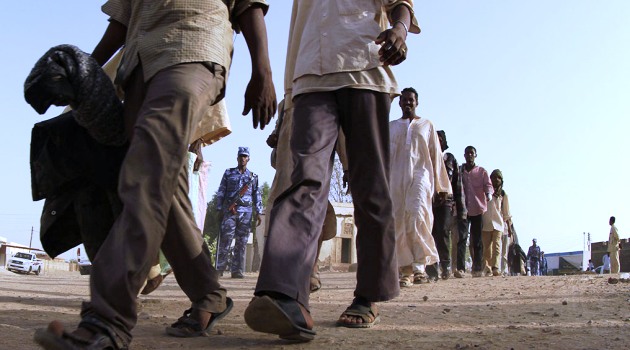 Illegal migrants who were abandoned in the desert by human traffickers gather at a military building in the northern Sudanese city of Dongola, on May 3, 2014/AFP