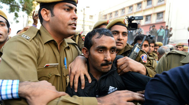 Indian police escort Uber driver Shiv Kumar Yadav following a court appearance in New Delhi on December 8, 2014/AFP