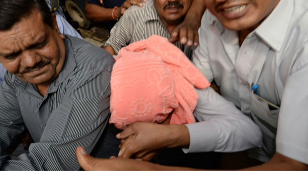 Indian policemen escort the juvenile accused in the December 2012 gang-rape of a student, to a court in New Delhi on August 31, 2013  © AFP