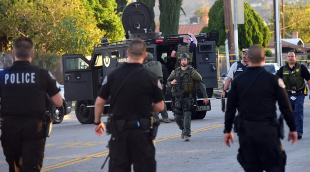 Police personnel from various departments walk along closed off streets in San Bernardino on December 2, 2015/AFP