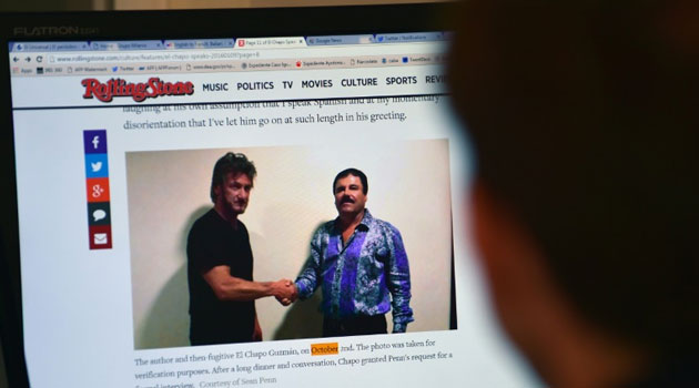 A man reads an article about Mexican drug lord Joaquin Guzman, aka 'El Chapo', showing a picture of him (R) and US actor Sean Penn, on the website of Rolling Stone magazine, on January 10, 2016/AFP