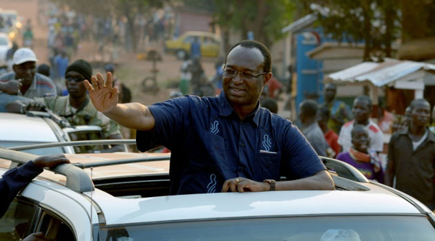 Central African Republic presidential candidate Anicet Georges Dologuele waves from a car during a presidential campaign tour in the capital Bangui on December 28, 2015/AFP