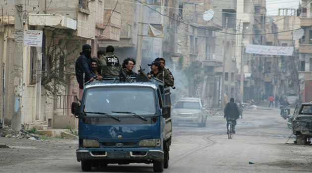 Rebels drive through the eastern Syrian town of Deir Ezzor on March 10, 2014/AFP