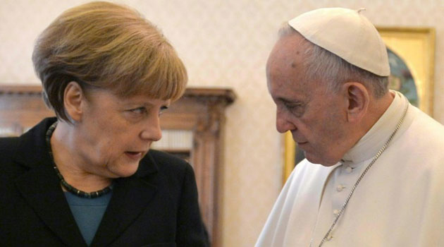 Pope Francis speaks with Angela Merkel during a 2015 meeting at the Vatican/AFP