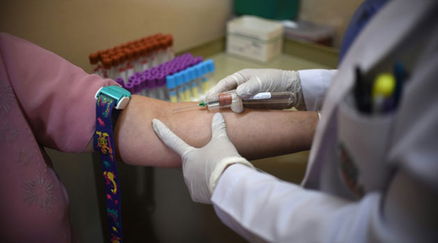 A paramedic takes a blood sample from a pregnant women in Guatemala City on February 2, 2016/AFP