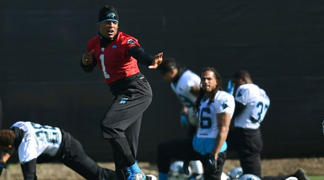 Quarterback Cam Newton of the Carolina Panthers gives the Heisman Trophy pose while his teammates stretch during practice  © Getty Images/AFP/File 