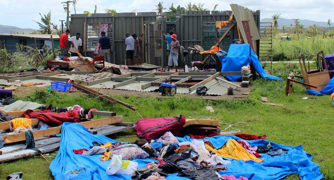  Residents salvaging belongings from the remains of a home following Cyclone/AFP