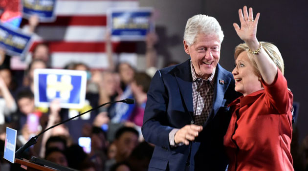 Democratic presidential candidate Hillary Clinton (R) and husband Bill Clinton (L) wave to a cheering crowd after winning the Nevada democratic caucus at Caesar's Palace in Las Vegas, Nevada on February 20, 2016/AFP