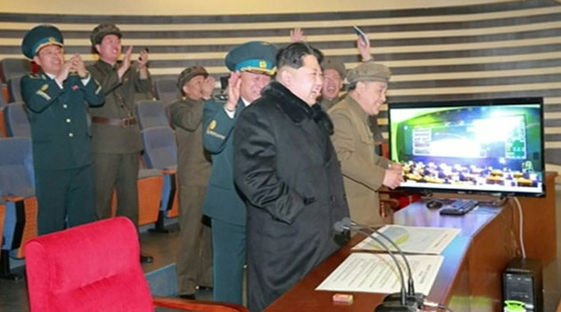 Picture taken from North Korean TV and released by South Korean news agency Yonhap shows North Korean leader Kim Jong-Un (3rd R) attending the rocket launch  © NORTH KOREAN TV/AFP