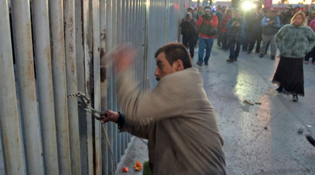 A relative of an inmate tries to break a chain and get into the Topo Chico prison/AFP