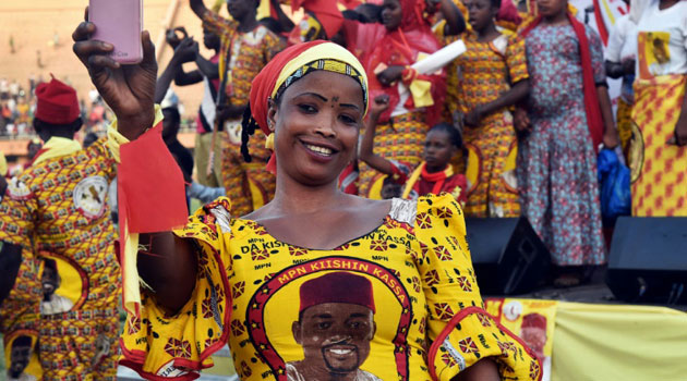 A supporter of Niger's presidential candidate, Ibrahim Yacouba, wears a dress with a picture of the candidate as she attends a presidential campaign rally in Niamey/AFP