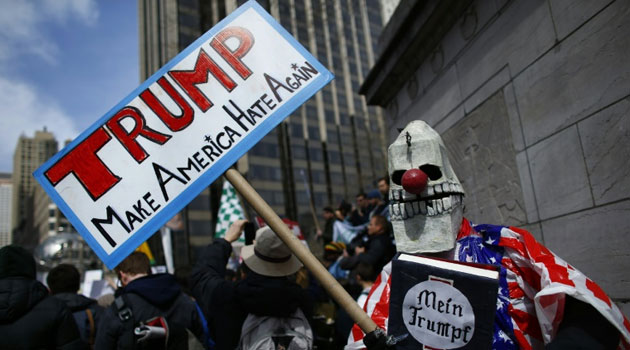 A man holds a banner as he takes part in a protest against Republican presidential front-runner Donald Trump in New York/AFP