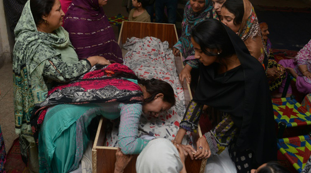 Relatives mourn over the body of a victim during a funeral following an overnight suicide bombing in Lahore/AFP