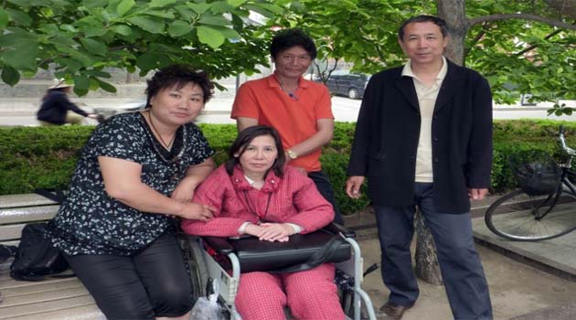 Ni Yulan (C) and her husband Dong Jiqin (3rd L) pose for a photo with friends during an interview in Beijing, in 2010/AFP