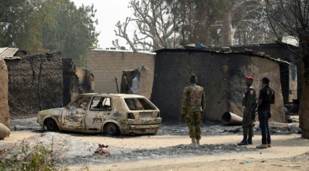 Nigerian soldiers inspect a burnt vehicle following a suicide attack by the Boko Haram militant group in Maiduguri, northeast Nigeria/AFP