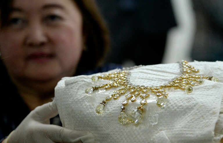 An official from the Presidential Commission on Good Government shows a diamond-studded piece of jewellery/AFP