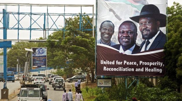 Pedestrians and traffic move past a billboard featuring portraits of the South Sudan's President Salva Kiir and the opposition leader Riek Machar in Juba/AFP