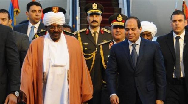 Egyptian President Abdel Fattah el-Sisi (C-R) walks alongside Sudanese President Omar al-Bashir (in robes) upon the latter’s arrival in the Red Sea resort of Sharm el-Sheikh ahead of an Arab League summit, March, 2015/AFP