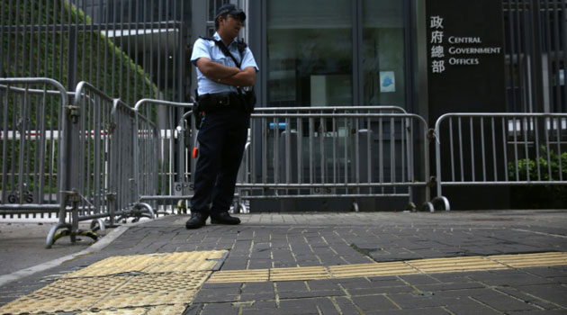 A policeman stands on pavement reinforced with glue to prevent the bricks from being dug up and used as projectiles during expected protests/AFP