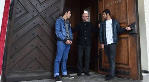  Pastor Peter Brummer speaks with the Iraqi immigrants Peshtiwan Nasser Abdal and Suud-iazdxn Arab in front of the Sant Joseph church in Tutzing, southern Germany, on May 24, 2016/AFP