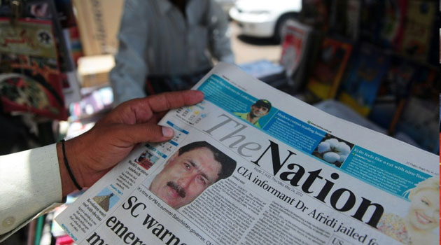 A newspaper bears the photograph of Pakistani surgeon Shakeel Afridi, recruited by the CIA to help find Osama bin Laden, at a newsstand in Karachi on May 24, 2012/FILE