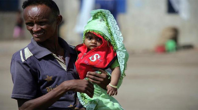  An Eritrean refugee holds his child at Sudan's Shagarab refugee camp in Kassala/AFP-File