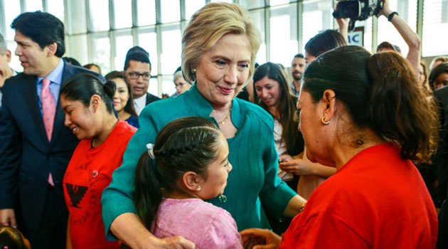 Democratic presidential candidate Hillary Clinton talks to an undocumented farm worker Maria Licea, 49, and her 9-year-old daughter Jasmin Aguilar at Los Angeles Mission College on June 4, 2016 in Sylmar, California/AFP 