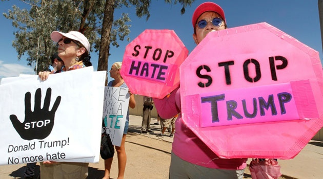 Edwina Vogan (left) and Virginia Havflaire hold anti-Trump signs on June 18, 2016 in Phoenix, Arizona/AFP