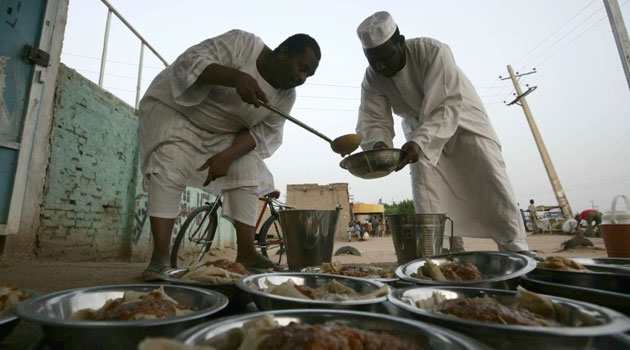 Sudanese men prepare food before an Iftar dinner by the side of the Khartoum highway in the village of al-Nuba Ramadan/AFP