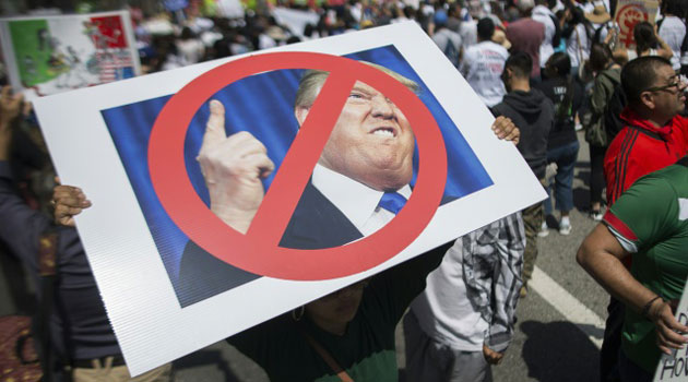 A woman carries a sign critical of Republican presidential candidate Donald Trump during a march on May 1, 2016 in Los Angeles, California/AFP