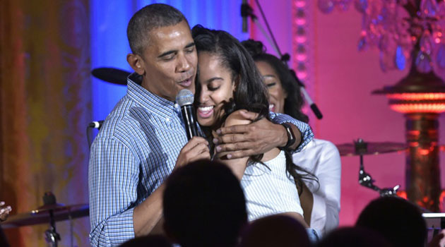 US President Barack Obama hugs his daughter Malia on her birthday during an Independence Day Celebration at the White House/AFP