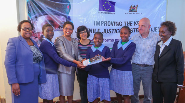 Chairperson, NCAJ- Special Task Force on Children Matters, Hon. Lady Justice Martha Koome (third left), European Union Representative, MitaManek (fourth left) and CESVI Kenya, Project Coordinator, Diego Ottolini present the newly launched publication to school kids/COURTESY