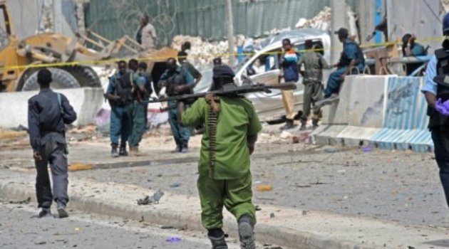 Somali soldiers secure a damaged perimeter wall following twin car bombings near Mogadishu's airport which left 13 dead/ AFP-File