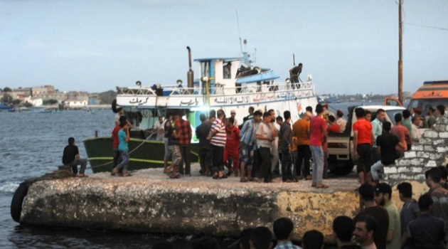 People gather along the shore in the Egyptian port city of Rosett during a search operation after a boat carrying migrants capsized in the Mediterranean/AFP