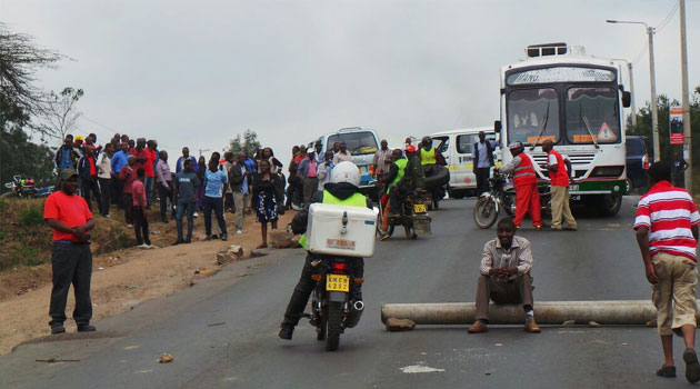 The protesters waved placards, while others shouted "enough is enough," as they walked down Lang'ata Road, with armed anti riot police officers watching from a distance/MOSES MUOKI