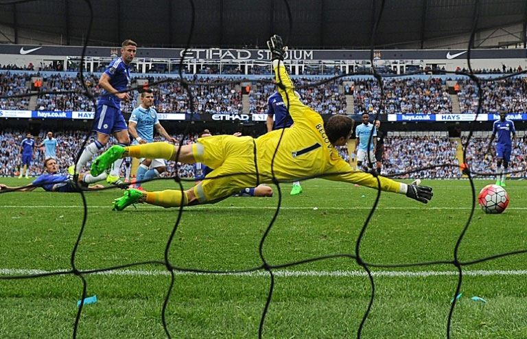 Chelsea's goalkeeper Asmir Begovic dives, but cannot prevent a shot from Manchester City's Sergio Aguero during the English Premier League match in Manchester on August 16, 2015. PHOTO/AFP