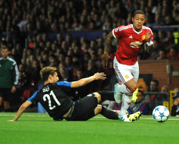 Manchester United's Memphis Depay, right, goes past Brugge's Dion Cools during the Champions League play-off round, first leg soccer match between Manchester United and Club Brugge at Old Trafford, Manchester, England, Tuesday, Aug. 18, 2015. PHOTO/AP