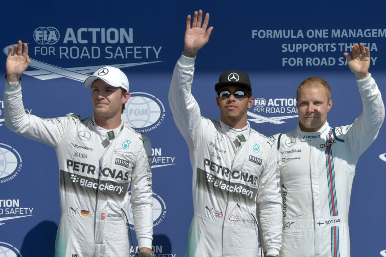 Lewis Hamilton (centre, Nico Rosberg (centre) and Valtteri Bottas celebrate in the parc ferme after the Belgian Grand Prix final qualifying session in Spa on August 22, 2015. PHOTO/AFP