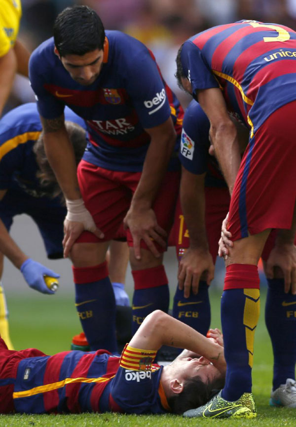 FC Barcelona's Lionel Messi lies on the pitch injured during a Spanish La Liga soccer match against Las Palmas at the Camp Nou stadium in Barcelona, Spain, Saturday, Sept. 26, 2015. PHOTO/AP/Yahoo!